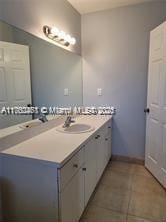 bathroom featuring tile patterned flooring, vanity, and baseboards