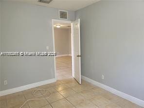 unfurnished room featuring visible vents, baseboards, and light tile patterned flooring