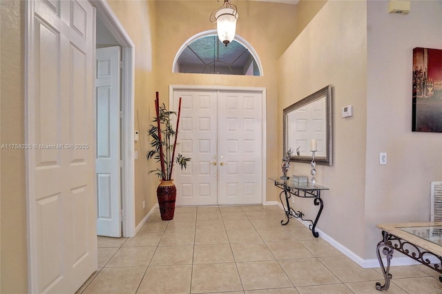 foyer featuring light tile patterned floors and baseboards