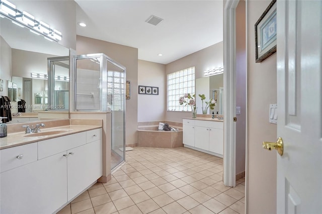 full bath with tile patterned flooring, visible vents, a garden tub, a stall shower, and a sink