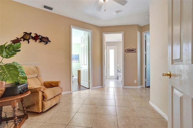 interior space with light tile patterned floors, visible vents, baseboards, and ceiling fan