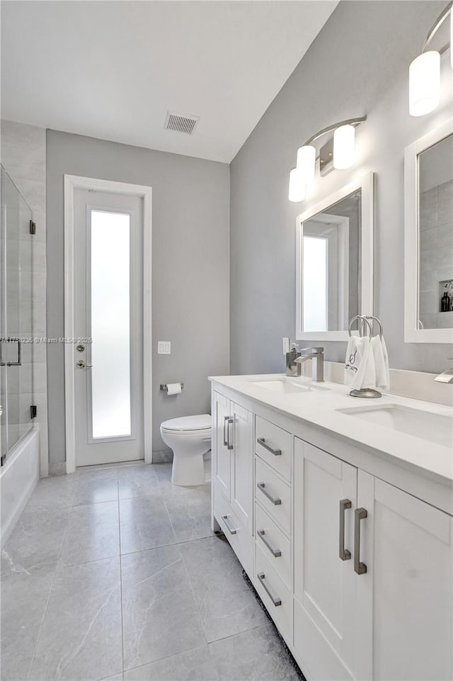 full bathroom with a sink, visible vents, toilet, and double vanity