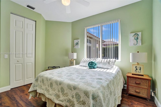 bedroom with a closet, visible vents, baseboards, and dark wood-style flooring