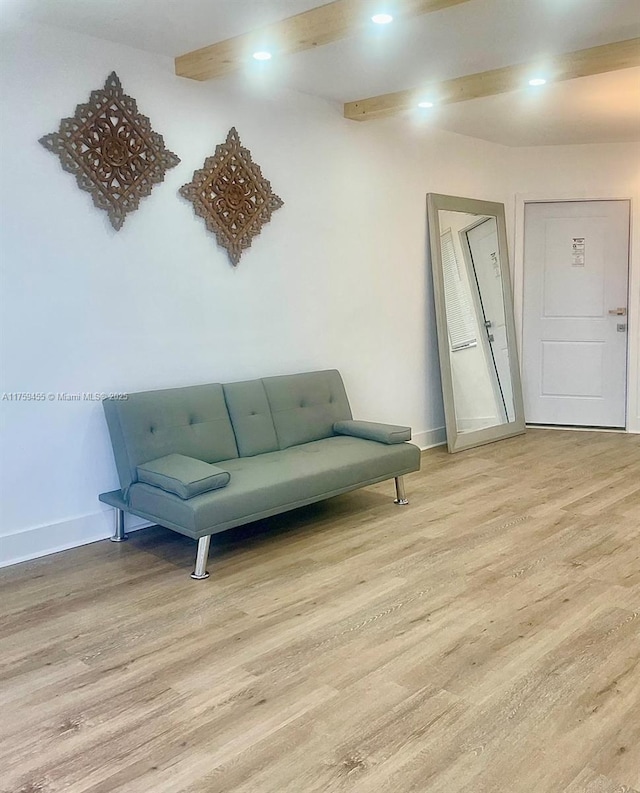 living area with beamed ceiling, recessed lighting, light wood-style floors, and baseboards