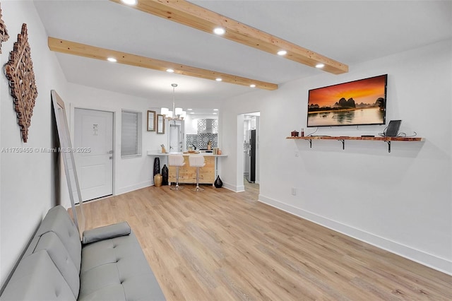 living room with light wood finished floors, baseboards, beamed ceiling, recessed lighting, and an inviting chandelier