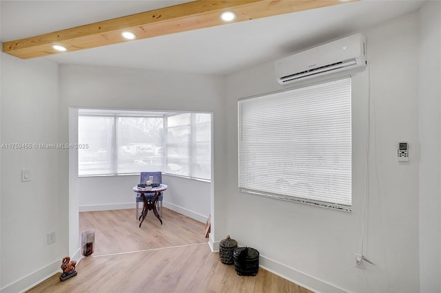 living area with recessed lighting, baseboards, an AC wall unit, and wood finished floors