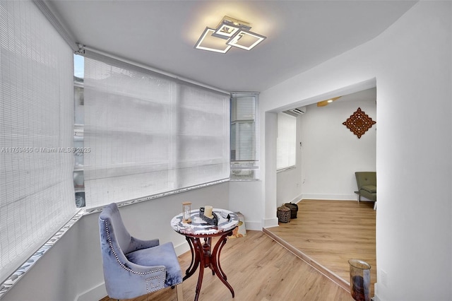 sitting room with baseboards and wood finished floors