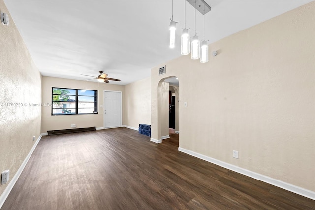 1311 N 19th Ave, Hollywood, FL 33020 - unfurnished living room with ceiling fan, arched walkways, dark wood-type flooring, baseboards, and a textured wall