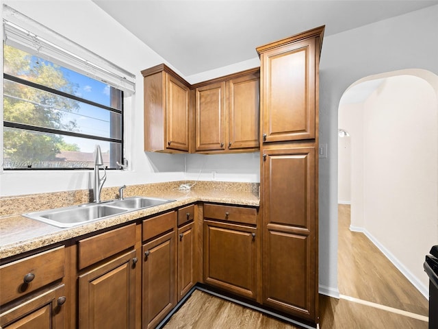 1311 N 19th Ave, Hollywood, FL 33020 - kitchen with a sink, arched walkways, light wood-style floors, and light countertops