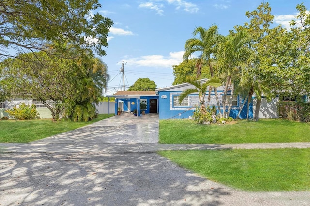 view of front facade featuring concrete driveway, a carport, and a front lawn