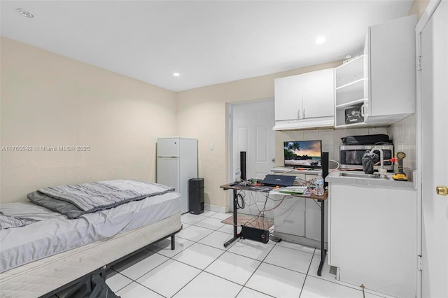 bedroom with light tile patterned floors, recessed lighting, and freestanding refrigerator