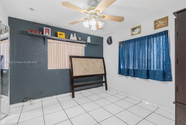 spare room featuring tile patterned floors and ceiling fan