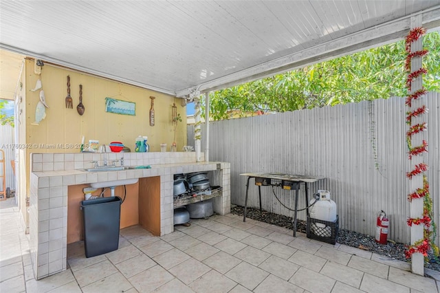 view of patio with fence and a sink