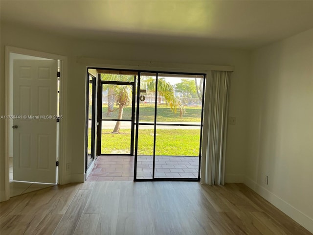 doorway with baseboards and wood finished floors