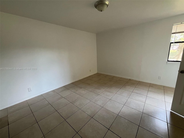 empty room featuring tile patterned floors and baseboards