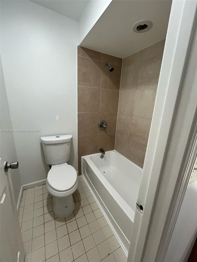 bathroom with tile patterned flooring, bathing tub / shower combination, toilet, and baseboards