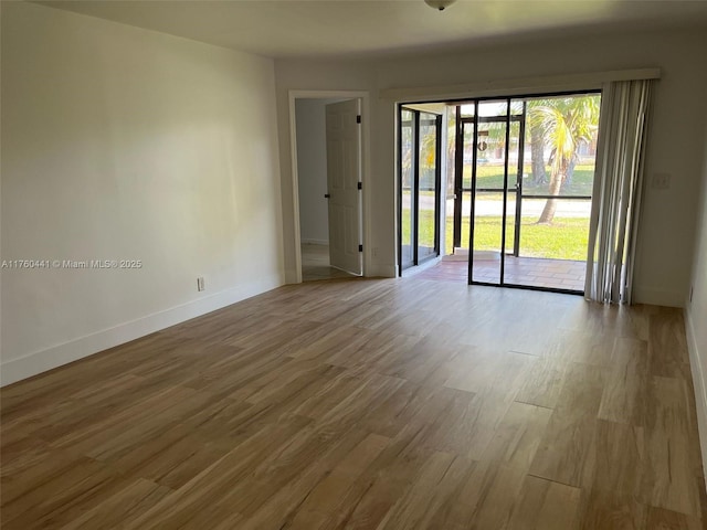 empty room with wood finished floors and baseboards