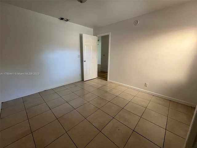 unfurnished room with tile patterned floors, visible vents, and baseboards