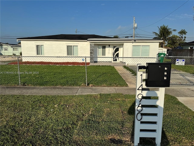 view of front of home with a fenced front yard, a front lawn, and a gate