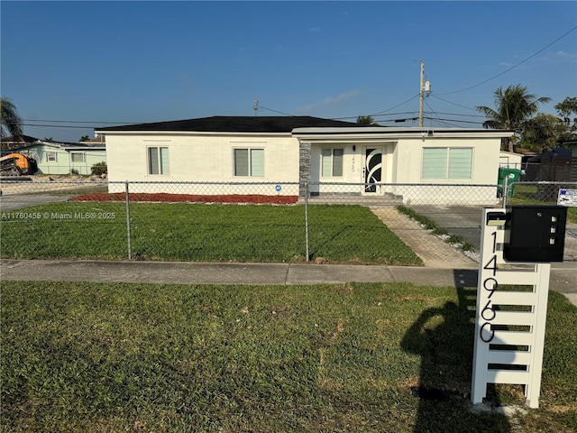 view of front of house featuring a fenced front yard, stucco siding, and a front lawn