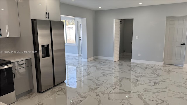 kitchen with recessed lighting, marble finish floor, appliances with stainless steel finishes, and baseboards