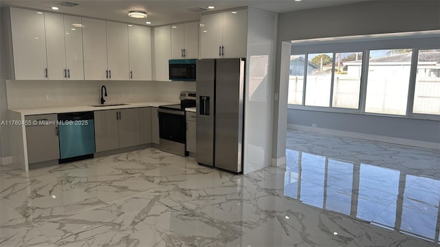 kitchen with a sink, light countertops, appliances with stainless steel finishes, white cabinetry, and marble finish floor