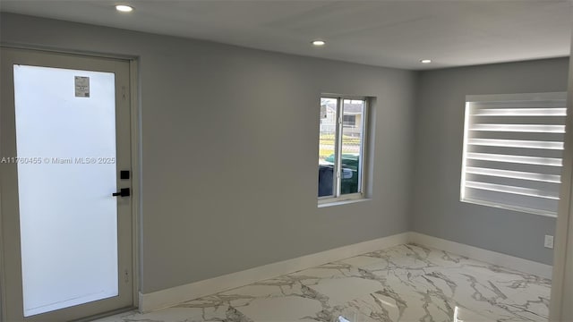 empty room with recessed lighting, baseboards, and marble finish floor