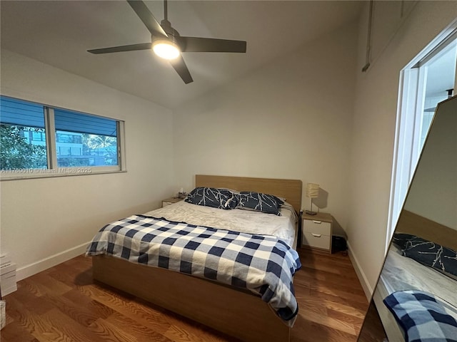 bedroom with lofted ceiling, wood finished floors, baseboards, and ceiling fan