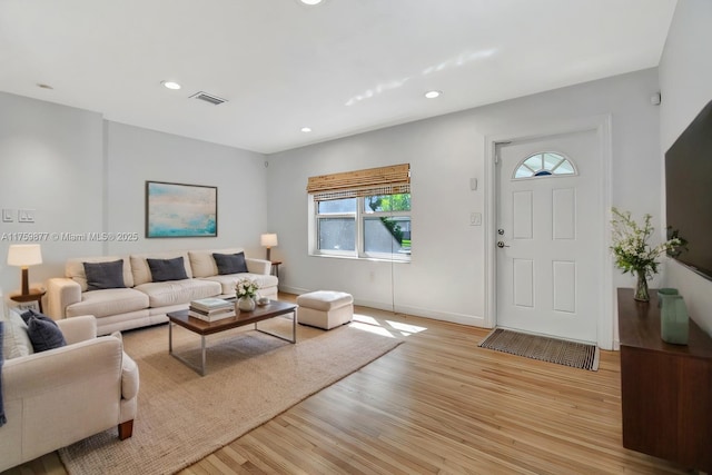 living room featuring light wood finished floors, visible vents, recessed lighting, and baseboards