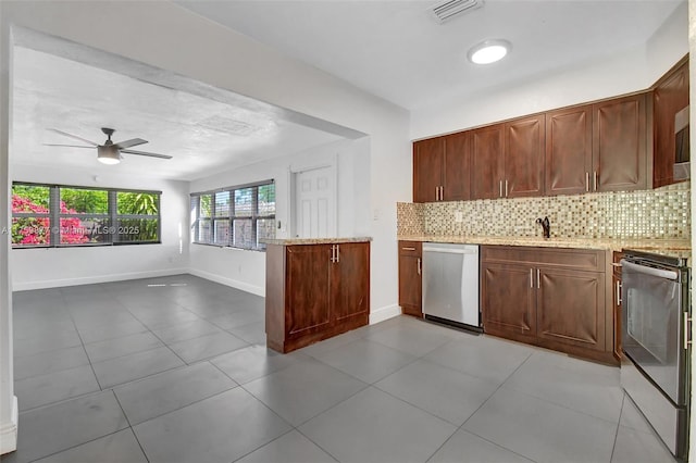 kitchen featuring light stone counters, visible vents, a peninsula, appliances with stainless steel finishes, and backsplash