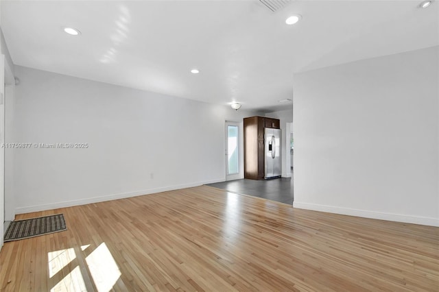 empty room with visible vents, recessed lighting, baseboards, and wood finished floors