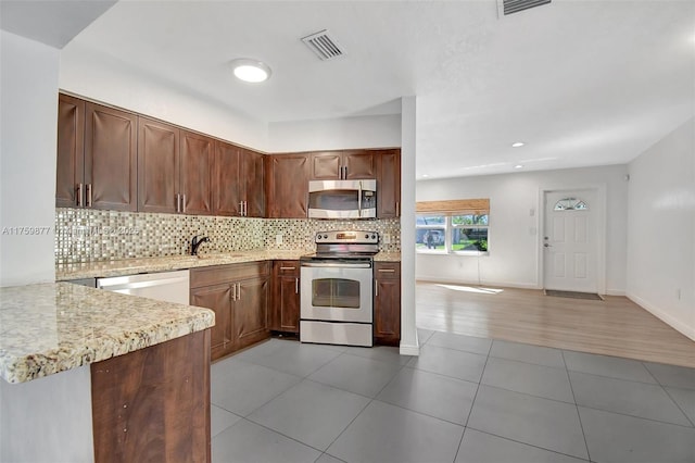 kitchen with tasteful backsplash, visible vents, appliances with stainless steel finishes, and light tile patterned floors