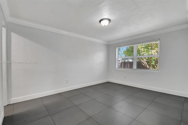 empty room featuring crown molding and baseboards