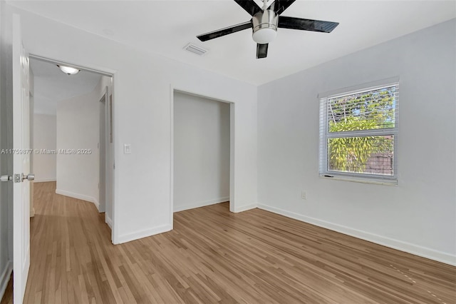 unfurnished bedroom featuring baseboards, visible vents, a closet, and light wood-type flooring