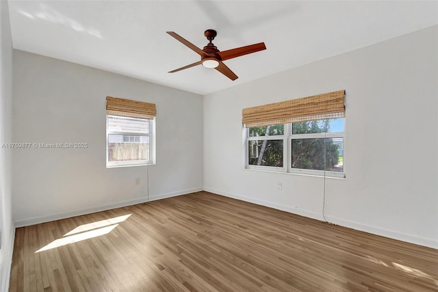 unfurnished room with a ceiling fan, baseboards, and wood finished floors