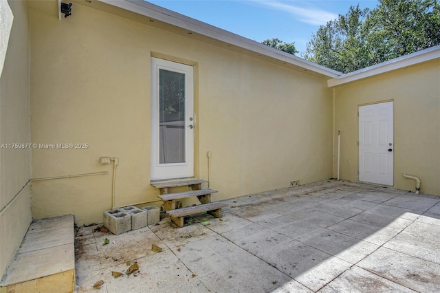 doorway to property featuring a patio area and stucco siding