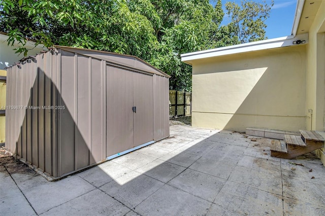 view of shed featuring fence