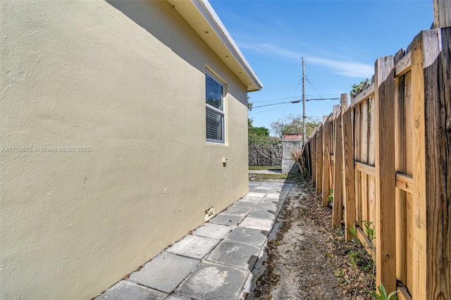 view of side of property featuring fence private yard and stucco siding