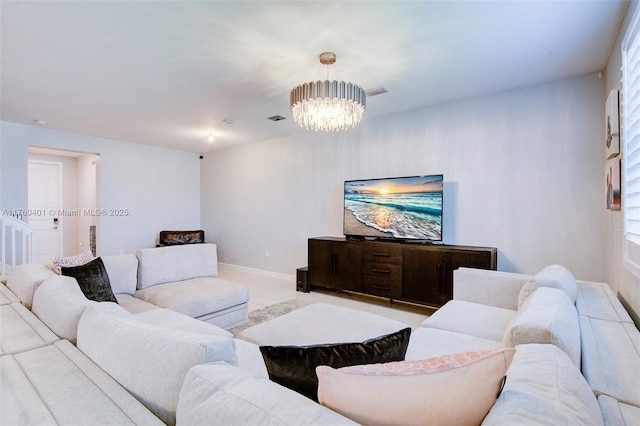 living area featuring a notable chandelier, baseboards, and visible vents