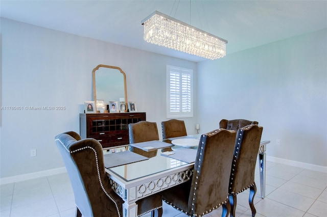 tiled dining room featuring baseboards and a notable chandelier