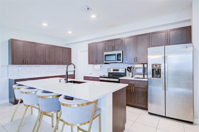 kitchen featuring dark brown cabinetry, visible vents, appliances with stainless steel finishes, and a sink