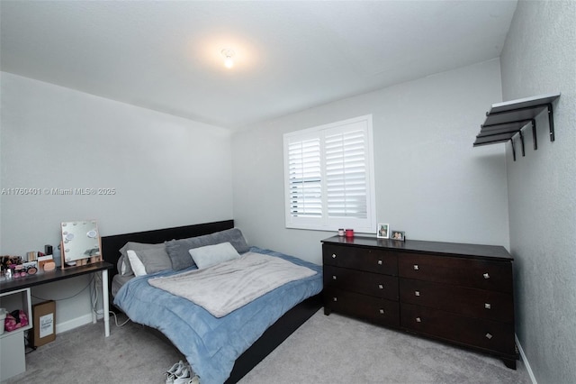 bedroom with light colored carpet and baseboards