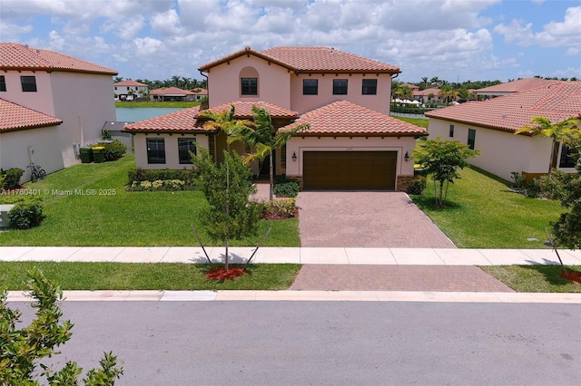 mediterranean / spanish house with stucco siding, a tile roof, decorative driveway, a front yard, and a garage