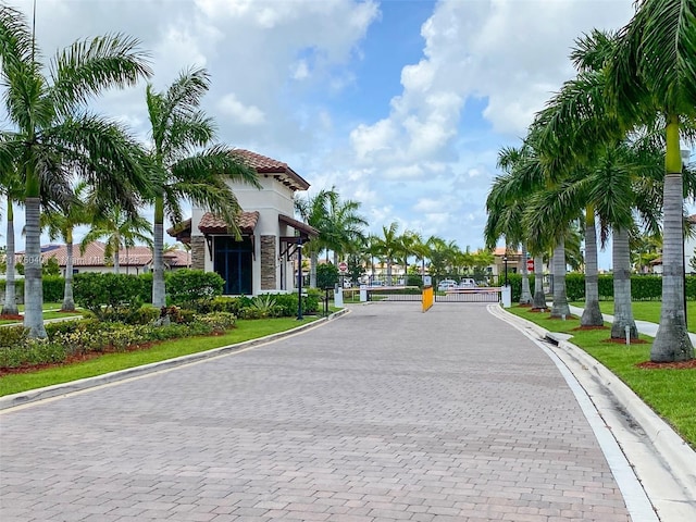 view of street with a gate, curbs, and a gated entry