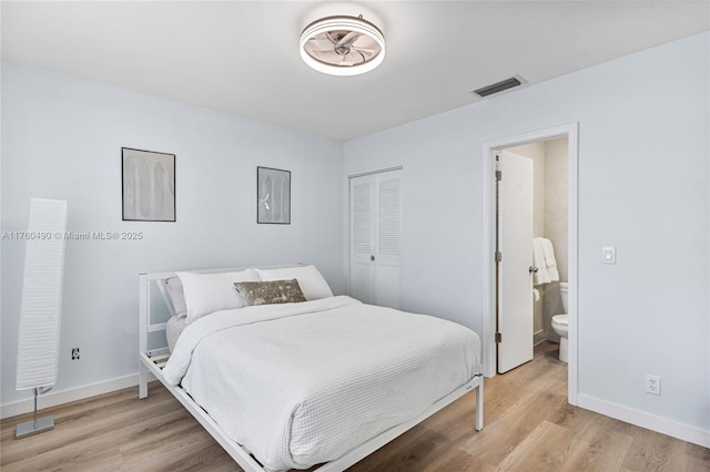 bedroom featuring light wood-type flooring, visible vents, and baseboards