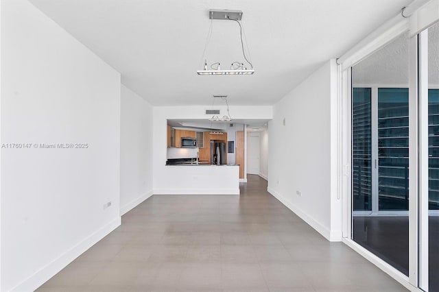 unfurnished living room featuring visible vents and baseboards