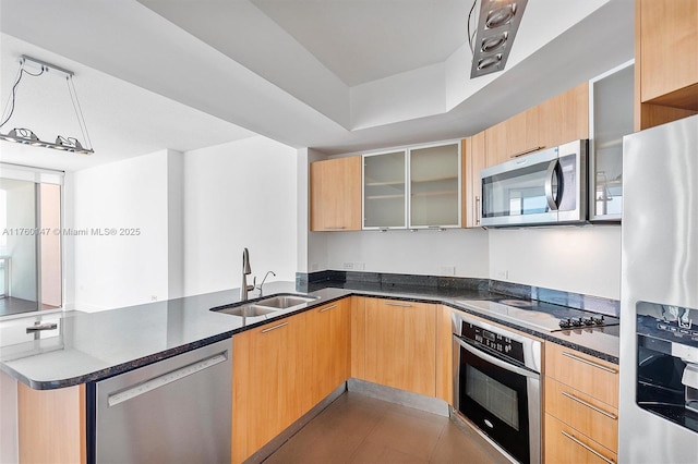 kitchen featuring a peninsula, stainless steel appliances, modern cabinets, and a sink