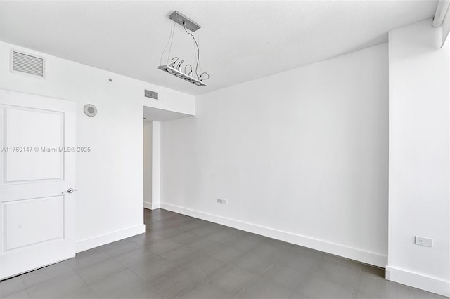 unfurnished room with visible vents and baseboards