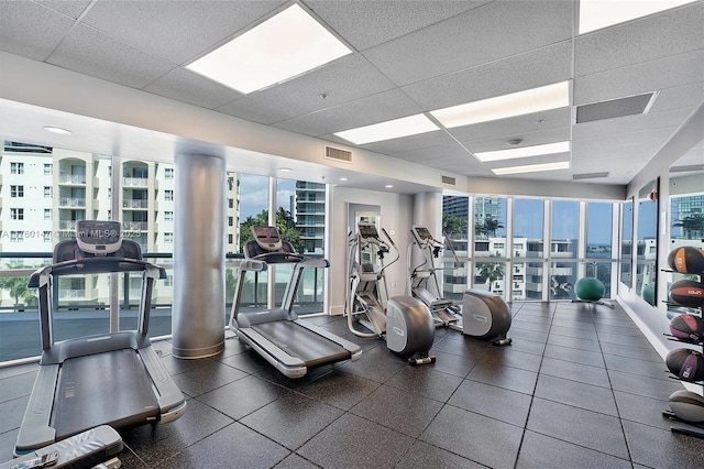 workout area with a view of city, a paneled ceiling, and visible vents