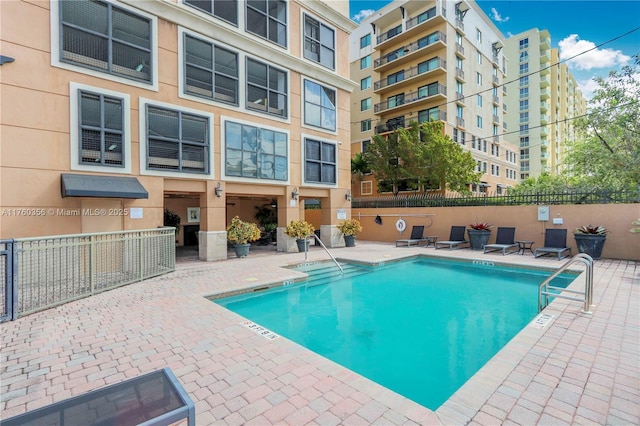 pool featuring fence and a patio area